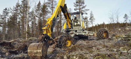 Spindelgrävaren tar sig över stock och sten